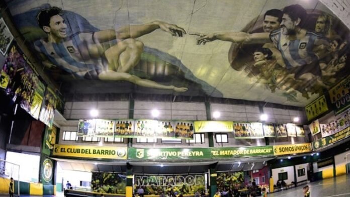 Niños juegan al fútbol en el club Sportivo Pereyra de Barracas, donde el artista local Santiago Barbeito pintó una versión futbolera de la obra de Miguel Angel 